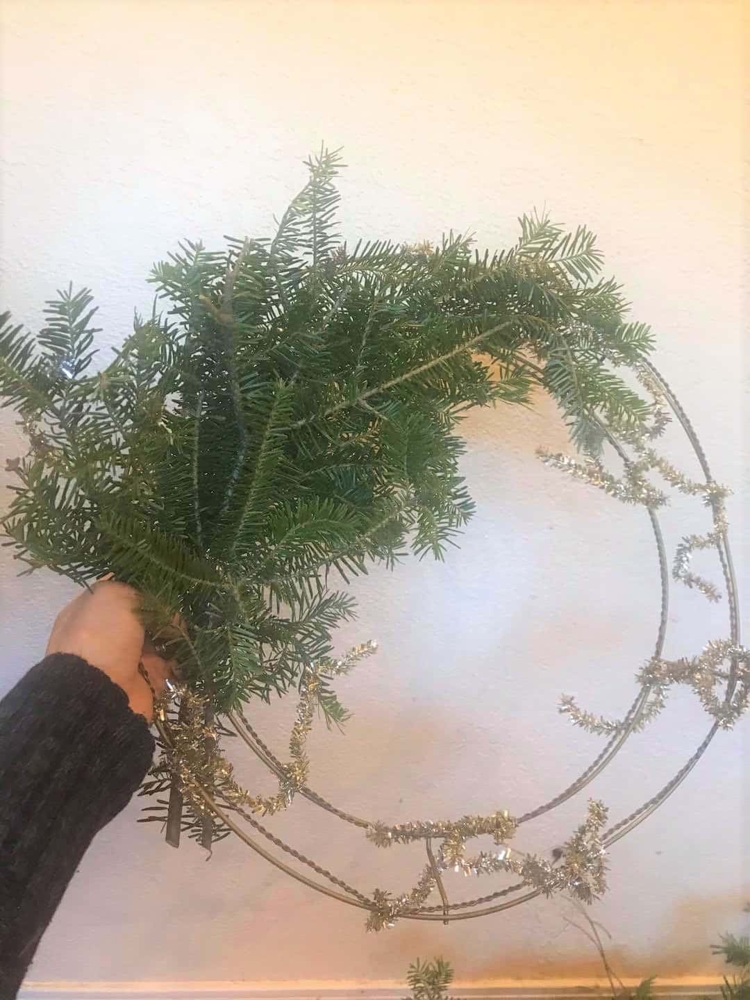 evergreen branches being attached to a wire wreath frame