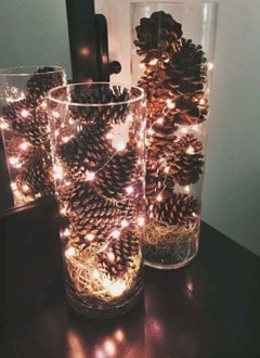 glass vase with pinecones and fairy lights