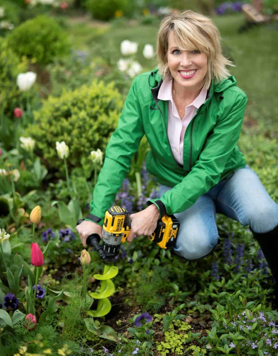 a woman uses a Power Planter auger to dig a hole in a garden