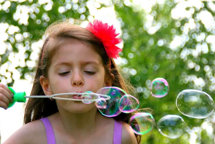 a girl blowing bubbles in a fun activity for kids