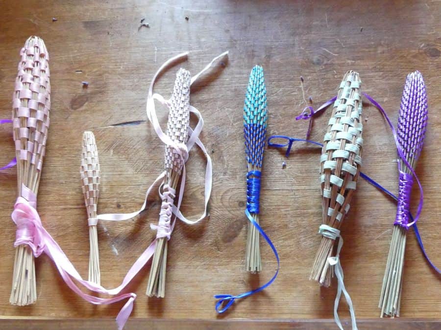 a collection of handmade lavender wands decorated with ribbon.