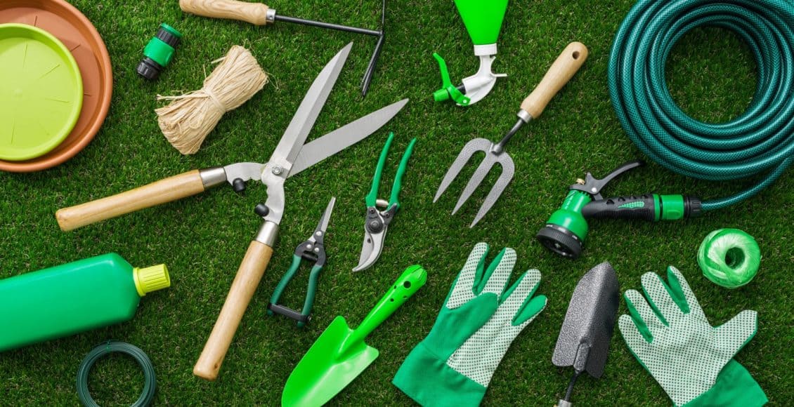 an assortment of the best garden tools spread out on a lawn