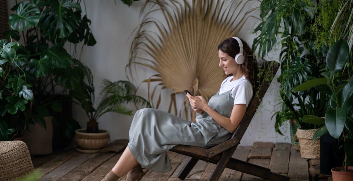 a woman listens to the best gardening podcasts