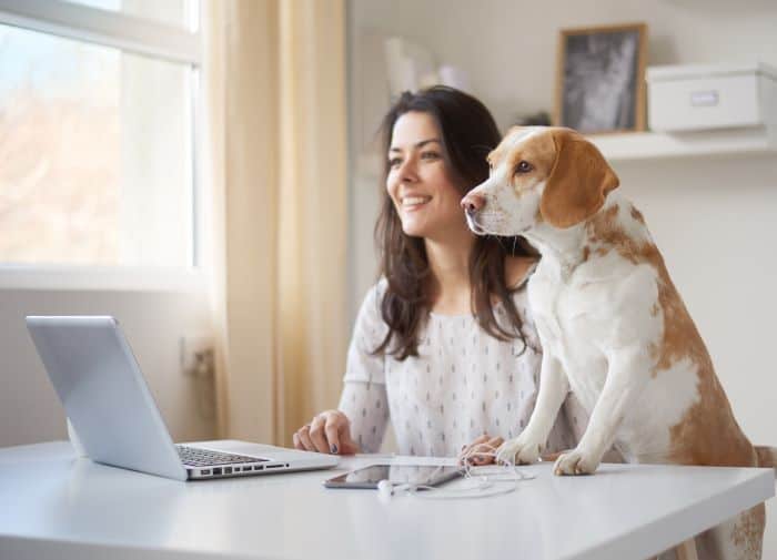 a woman and a dog look at computer screen